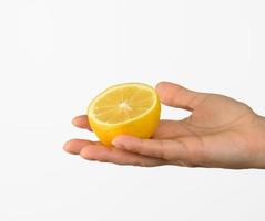 kvinna hand innehar halv en gul citron- på en vit bakgrund foto