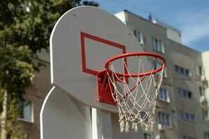 basketboll ring för spelar basketboll på de gata med byggnader på de bakgrund foto