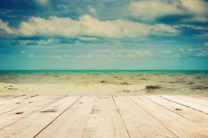 trä tabell och strand hav och moln i sommar med årgång tona. foto