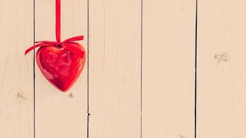 dekorativ röd hjärtan hängande på årgång trä- med Plats. valentine bakgrund. foto