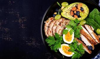 ketogen diet. buddha skål maträtt med köttfärslimpa, kyckling kött, avokado, bär och nötter. detox och friska begrepp. keto mat. över huvudet, topp se, platt lägga foto