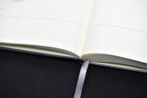 ett öppen bok på en svart bakgrund. ett öppen anteckningsbok. tom sidor av de anteckningsbok. foto