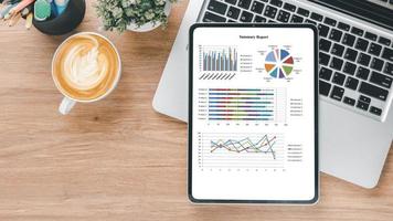 läsplatta med diagram och rapporter på kontor skrivbord arbetsplats. topp se platt lägga foto