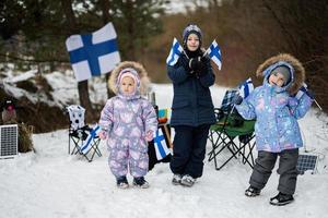 tre finska barn med finland flaggor på en trevlig vinter- dag. nordic scandinavian människor. foto