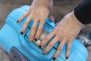 detalj av kvinna händer är stängning en resväska foto