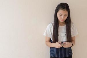 ung asiatisk tjej som använder smart telefon foto