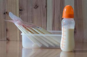 bröstmjölk i flaska för barn med träbakgrund foto
