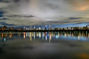 manhattan horisont se på natt från central parkera tvärs över de central parkera reservoar. foto