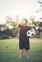 liten pojke som spelar fotboll fotboll foto