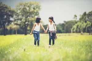 två små flickor som håller hand i parken foto