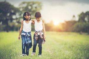 två små flickor som har kul i parken foto