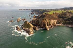 tystnad strand, silver-sandig cove stöd förbi en naturlig sten amfiteater i asturien, Spanien. foto