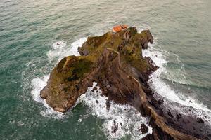 grön klippig bergen och kustlinje landskap, san juan de gaztelugatxe, Spanien foto