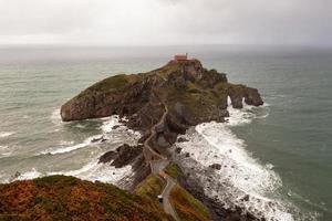 grön klippig bergen och kustlinje landskap, san juan de gaztelugatxe, Spanien foto