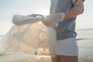 spara vatten. volontär- plocka upp skräp sopor på de strand och plast flaskor är svår bryta ned förhindra skada vatten- liv. jorden, miljö, grönare planet, minska global uppvärmning, spara värld foto