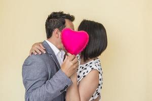 kärleksfull par kissing och dölja Bakom ballong foto