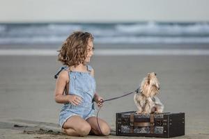 positiv flicka och hund under sommar semester på strand foto