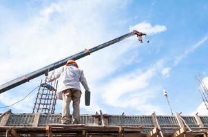 konstruktion arbetare arbetssätt på byggnadsställningar med plåster och spatel, man arbetssätt på de arbetssätt på höjd med blå himmel på konstruktion webbplats foto