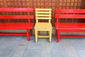 röd och gul trä- bänk stolar i de parkera. foto