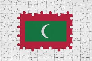 maldiverna flagga i ram av vit pussel bitar med saknas central del foto