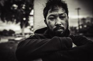 asiatisk man är hemlös på de sida väg, en främling har till leva på de väg ensam eftersom han har Nej familj. foto