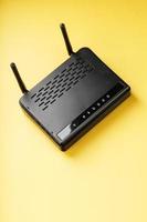 Wi-Fi router i svart på en gul bakgrund med fri Plats. foto