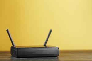 Wi-Fi router i svart på en gul bakgrund med fri Plats. foto