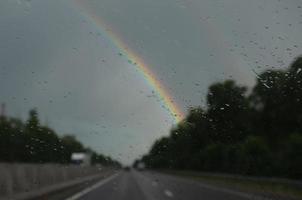 suddigt se från de bil fönster på en regnbåge i de regn foto