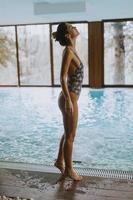vacker ung kvinna som står vid poolen foto