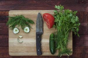 Ingredienser för en friska sallad tomater, gurkor och örter foto