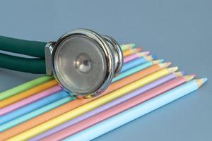 prov av färgad pennor och en stetoskop representerar de pediatrisk läkare foto
