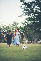 liten pojke som spelar fotbollsfotboll med mamma i parken foto