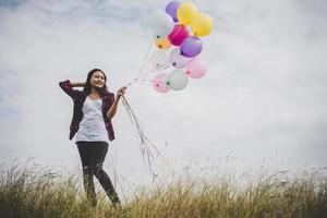 vacker ung hipster kvinna med färgglada ballonger utomhus foto