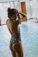 vacker ung kvinna som står vid poolen foto