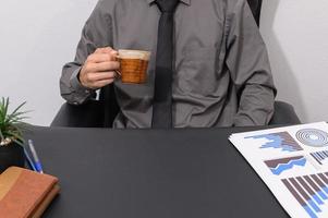 en affärsman som dricker kaffe vid sitt skrivbord foto