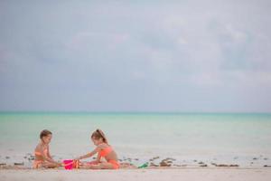 liten flickor spelar på de strand foto