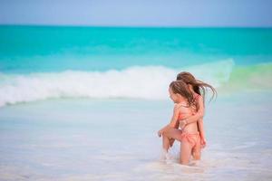 liten flickor spelar på de strand foto