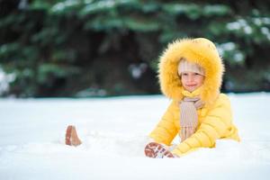 liten flicka spelar i de snö foto