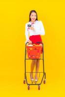 vacker ung asiatisk kvinna med kundvagn foto