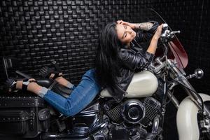 förtjusande kvinna liggande på en motorcykel foto