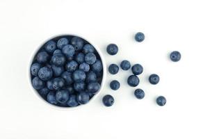 blåbär i keramisk skål bredvid bär frukt foto