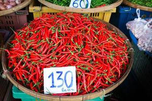 färsk röd varm chilipeppar i en korg såld på lokal- marknadsföra på thailand foto