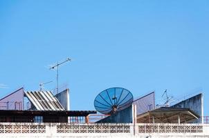 satellit maträtt och tv antenn på de gammal byggnad med de blå himmel bakgrund i de morgon- foto