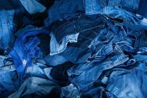 stack av olika nyanser blå jeans. lugg blå denim jeans textur baner. duk denim mode textur foto