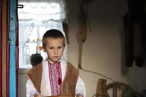 slavic liten pojke vitryska eller ukrainska i nationell kläder på en rustik bakgrund. foto