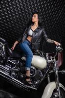trevlig kvinna Sammanträde på en motorcykel foto