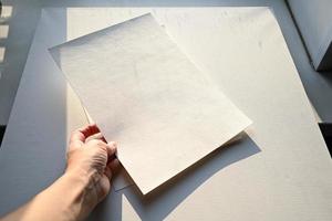 närbild av barns händer teckning med en penna på vit papper. i de bearbeta av arbete. foto