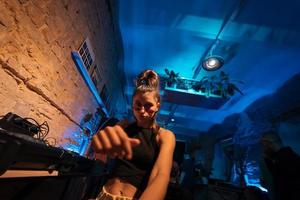 skön kvinna dj dans till techno i en små klubb foto