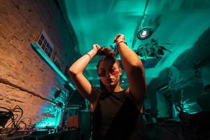 skön kvinna dj dans till techno i en små klubb foto