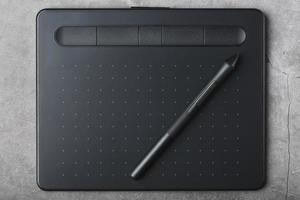 grafisk läsplatta med en penna på en grå bakgrund, de arbete av en designer, konstnär och fotograf. de se från de topp foto